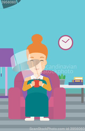 Image of Woman sitting in chair with cup of tea.