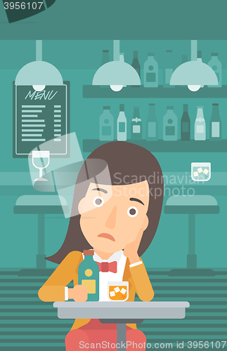 Image of Sad woman with bottle and glass.