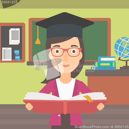 Image of Woman in graduation cap holding book.