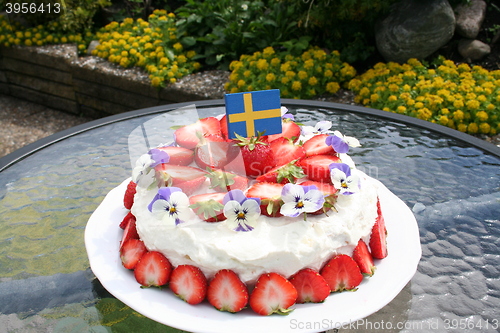 Image of Midsummer gateau with strawberries, cream, Swedish flag  and pansies