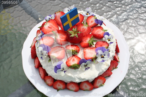 Image of Gateau with strawberries, Swedish flag and pansies