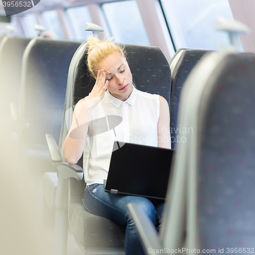 Image of Woman sleeping while travelling by train.