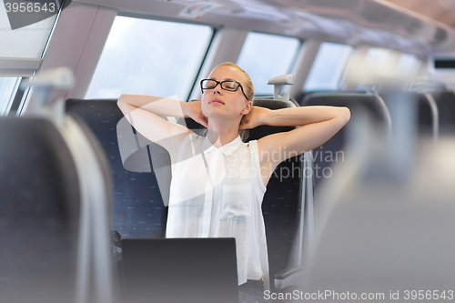 Image of Woman streching while travelling by train.