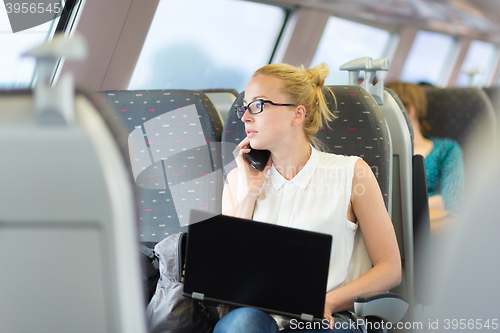 Image of Business woman working while travelling by train.