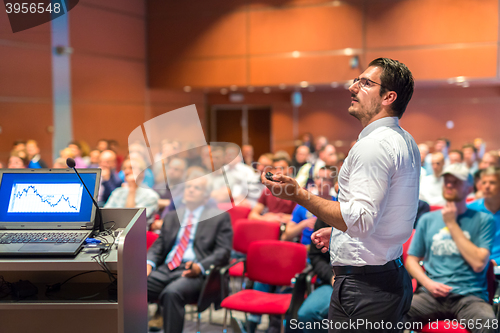 Image of Public speaker giving talk at Business Event.