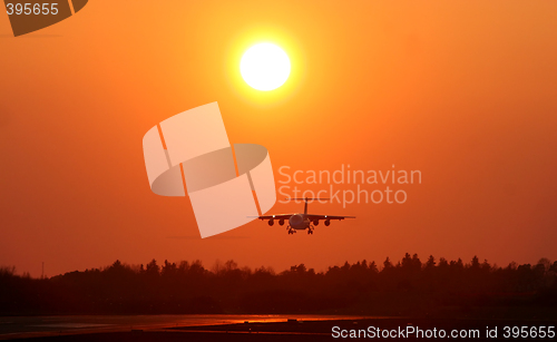 Image of Airplane landing at sunset