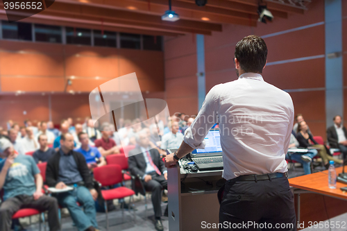 Image of Public speaker giving talk at Business Event.