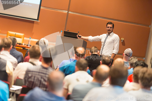 Image of Business speaker giving a talk in conference hall.