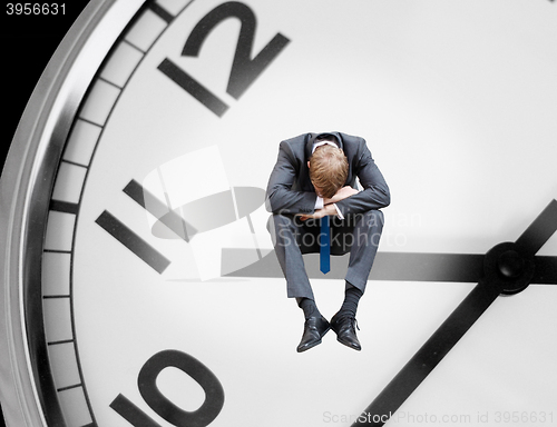 Image of Depressed businessman on clock