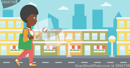 Image of Woman walking with smartphone.