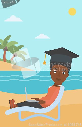 Image of Graduate lying on chaise lounge with laptop.