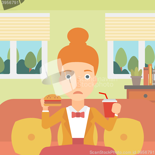Image of Woman eating hamburger. 