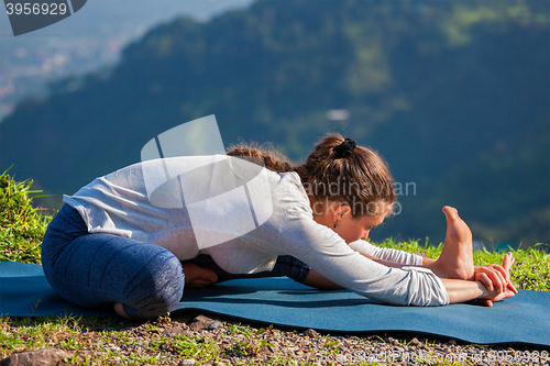 Image of Woman doing Ashtanga Vinyasa yoga Janu Sirsasana A asana stretch