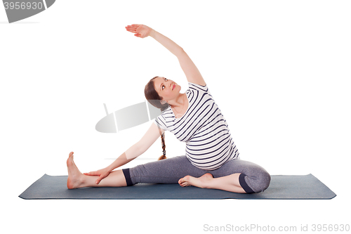 Image of Pregnant woman doing yoga asana Parivrtta janu sirsasana