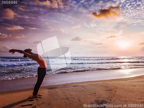 Image of Young sporty fit woman doing yoga Sun salutation Surya Namaskar