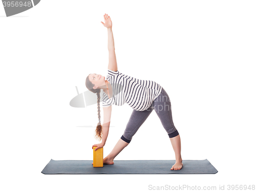 Image of Pregnant woman doing yoga asana Utthita trikonasana