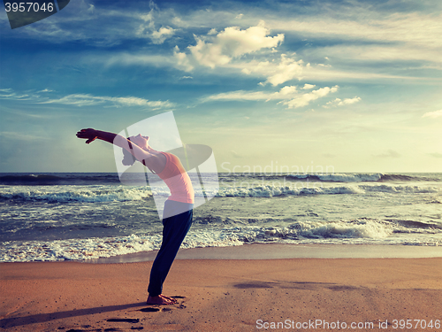 Image of Young sporty fit woman doing yoga Sun salutation Surya Namaskar