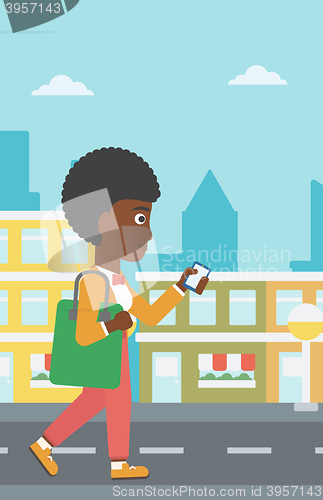 Image of Woman walking with smartphone.