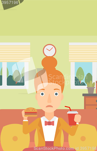 Image of Woman eating hamburger. 