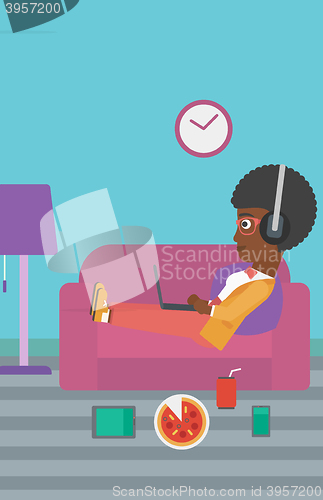 Image of Woman lying on sofa with many gadgets.