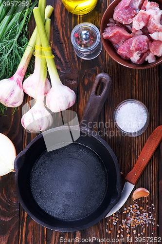 Image of raw meat and pan on a table