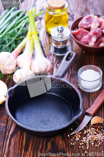 Image of raw meat and pan on a table