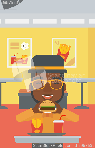 Image of Man eating hamburger. 