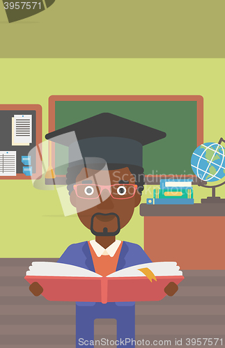 Image of Man in graduation cap holding book.