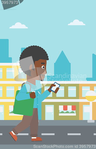 Image of Man walking with smartphone.