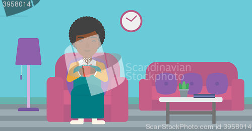 Image of Woman sitting in chair with cup of tea.