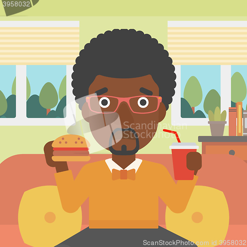 Image of Man eating hamburger. 