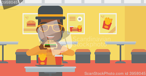 Image of Man eating hamburger. 