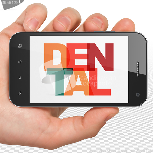 Image of Health concept: Hand Holding Smartphone with Dental on  display