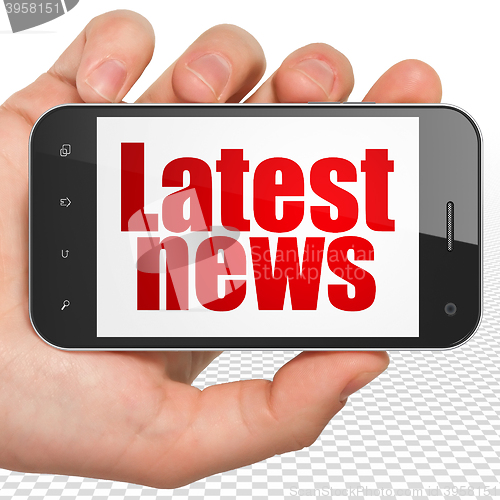 Image of News concept: Hand Holding Smartphone with Latest News on display