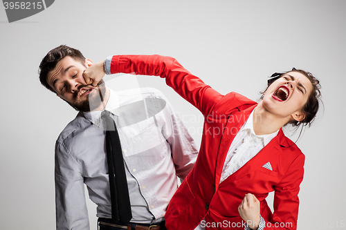 Image of The angry business man and woman conflicting on a gray background