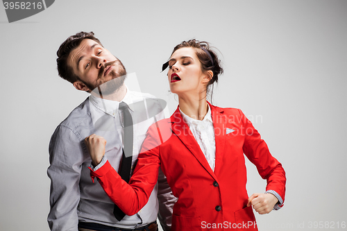 Image of The angry business man and woman conflicting on a gray background