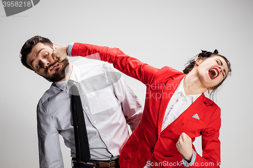 Image of The angry business man and woman conflicting on a gray background