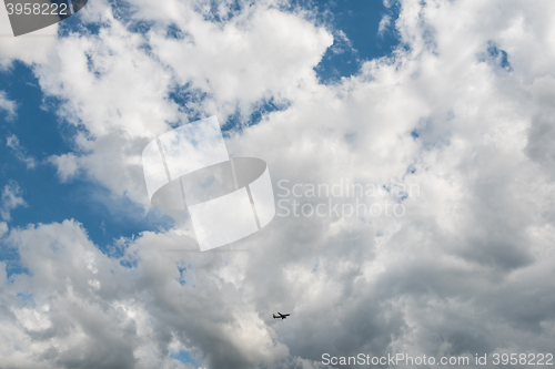 Image of Airplane flying high in dramatic clouds