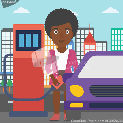 Image of Woman filling up fuel into car.