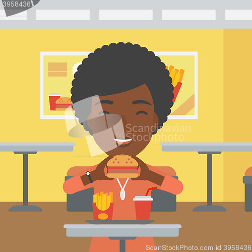 Image of Woman eating hamburger. 