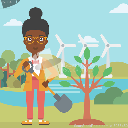 Image of Woman plants tree.