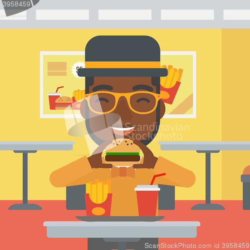 Image of Man eating hamburger. 