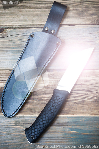 Image of shiny hunting knife and leather scabbard