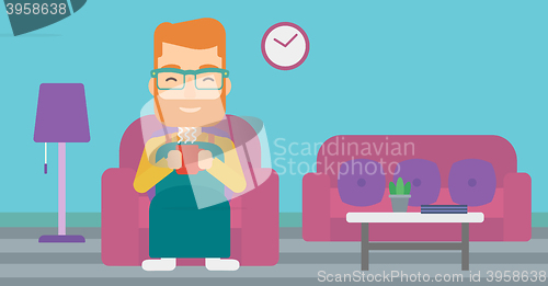 Image of Man sitting in chair with cup of tea.