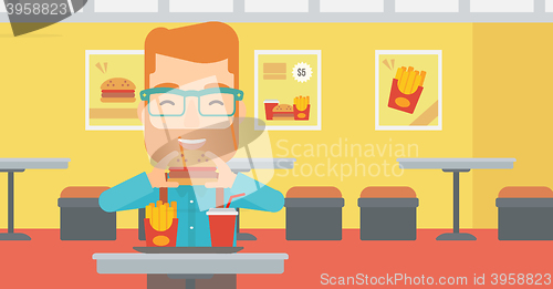 Image of Man eating hamburger. 