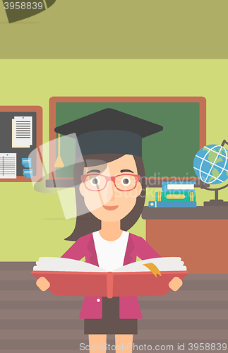 Image of Woman in graduation cap holding book.