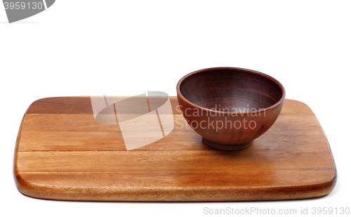 Image of Empty ceramic bowl on wooden kitchen board