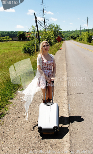 Image of Young woman walking along street.