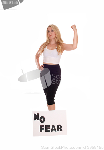 Image of Woman standing with sign NO FEAR.