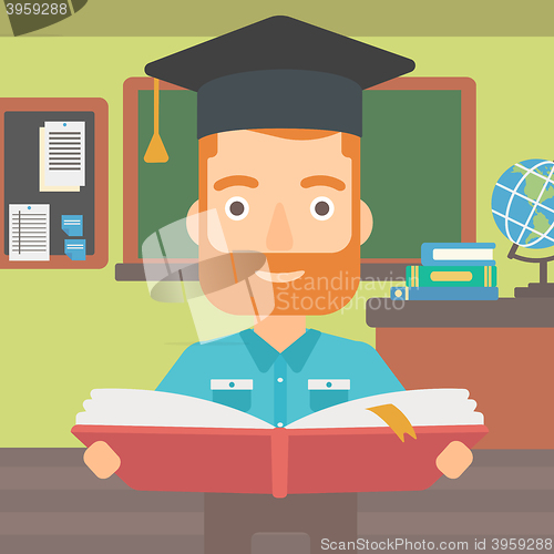Image of Man in graduation cap holding book.